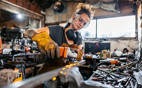 A lady working with metal in her small business workshop