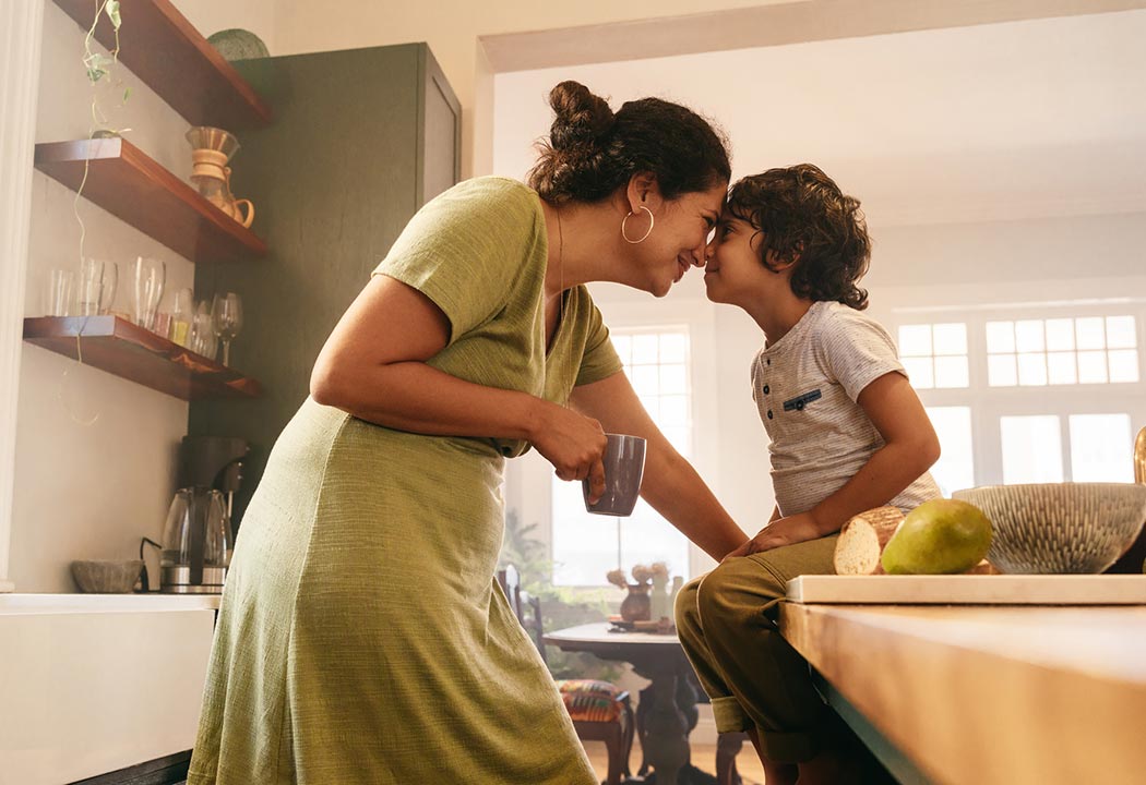 A mom and her young son talking in their kitchen